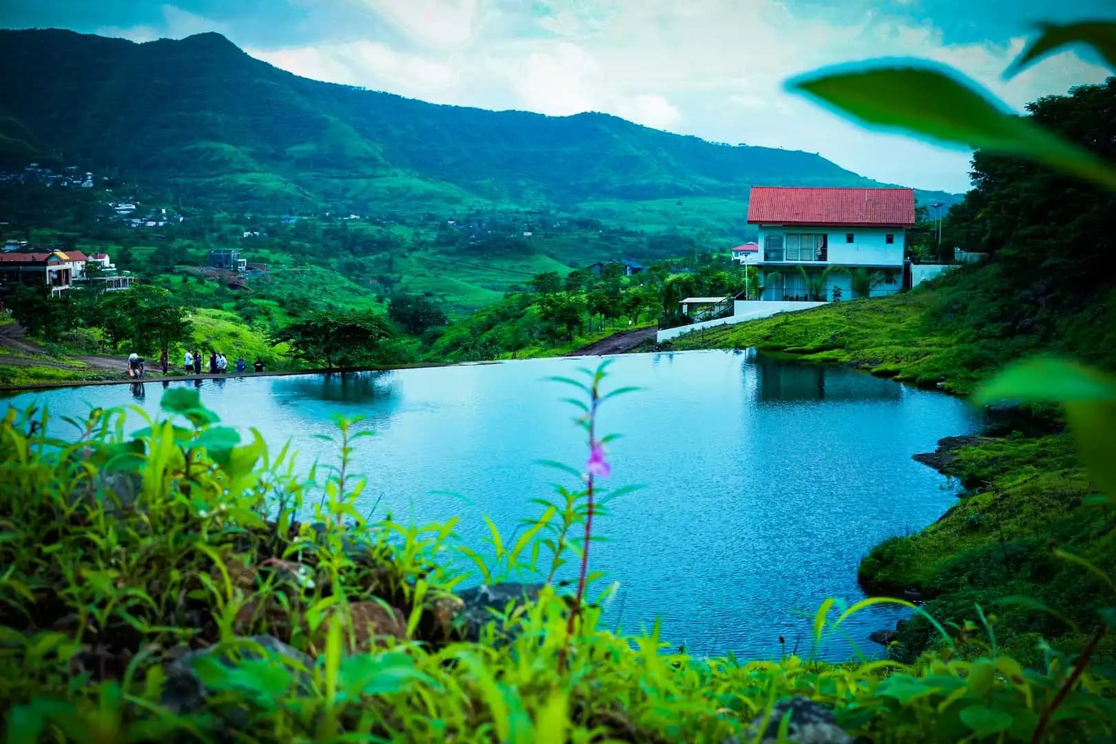 Man-made lake with villa and green hills at Royal Purandar